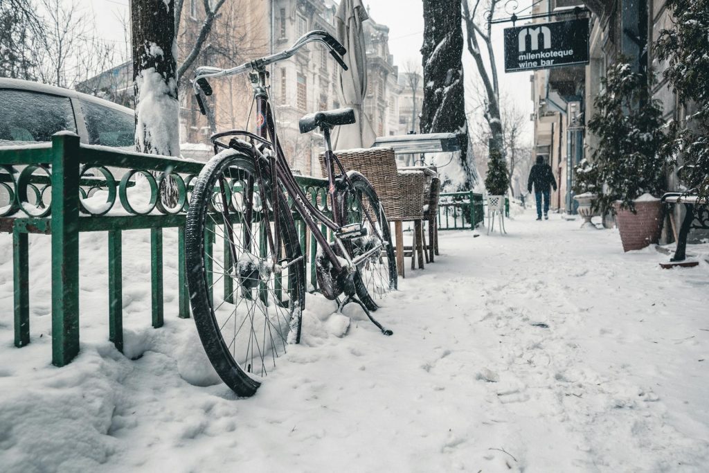 Person walking on icy, snow-covered sidewalk in winter