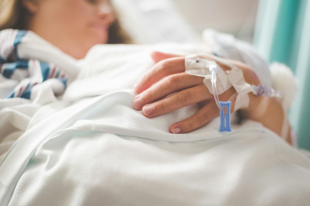 A woman lying in a hospital bed with an IV after a personal injury accident