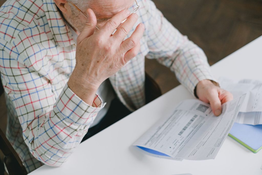An older man reviewing a denied insurance claim letter